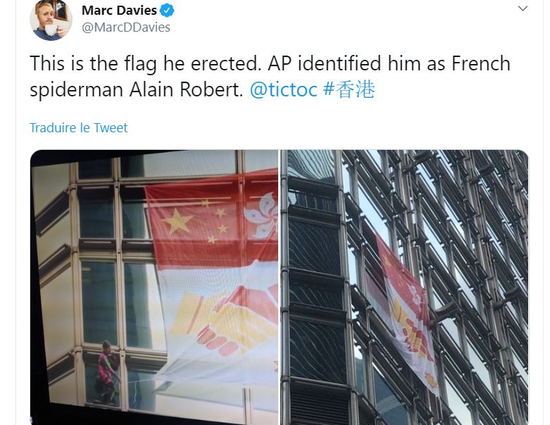 Alain Robert, le “Spiderman” français, déploye une banderole pour la paix à Hong-Kong